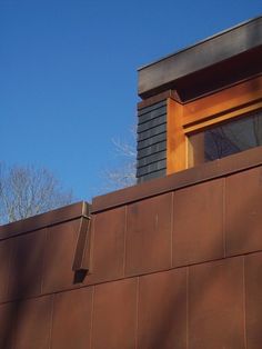 a building with a clock on the side of it's face and trees in the background