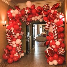 the balloon arch is decorated with red and white candy canes, balloons, and streamers