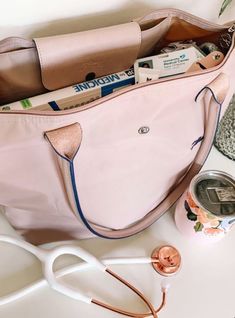 a pink purse sitting on top of a white table next to scissors and other items