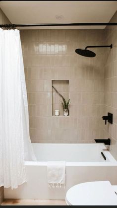 a white bath tub sitting next to a toilet