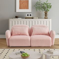 a living room with two pink couches and a coffee table