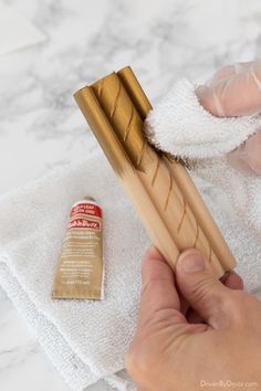 a person is holding a toothbrush and cleaning it with a cloth on the counter