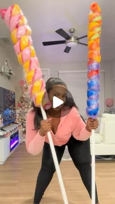 a woman holding two large candy canes in her hands