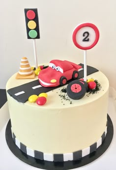 a birthday cake decorated with a car and traffic signs