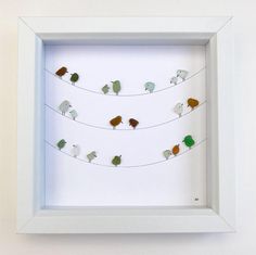 several birds are sitting on wires in a shadow box with white trim around the edges