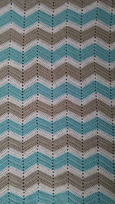 a crocheted blanket is shown with blue and gray stripes