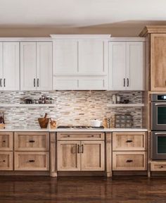 a kitchen with white cabinets and wood floors