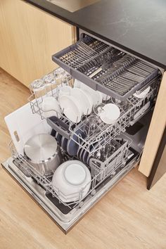 an open dishwasher with dishes in it