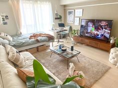 a living room filled with furniture and a flat screen tv on top of a wooden table