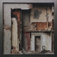 an old building with peeling paint on the walls and a chair sitting in the doorway