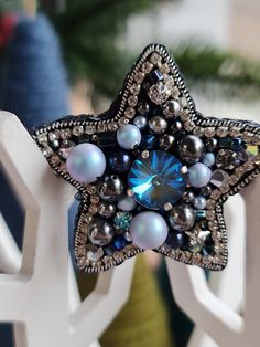 a close up of a star brooch on a white chair