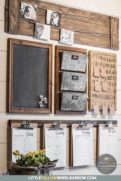 a wall with several calendars hanging on it's sides and flowers in a basket