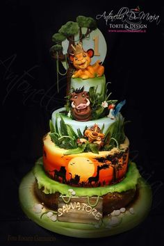 a three tiered cake decorated with animals and plants