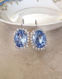 Gorgeous pair of statement size earrings featuring 18x13mm light Sapphire blue oval rhinestones surrounded by tiny sparkling clear crystals. Lever back closure for pierced ears. Thanks for stopping by. Blue Halo Setting Earrings For Wedding, Blue Halo Earrings For Wedding, Blue Oval Earrings For Wedding, Blue Bling Wedding Jewelry, Blue Bling Jewelry For Wedding, Blue Oval Party Jewelry, Bridal Party Blue, Wedding Something Blue, Blue Earrings Wedding