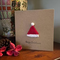 a card with a knitted santa hat on it