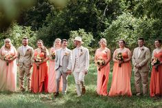 a group of people standing next to each other in front of some trees and grass