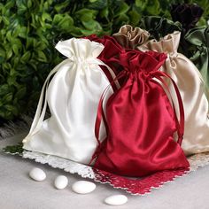 three bags with white and red draws are sitting next to each other on a lace doily