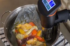 there is a bag full of food in the pot with an electronic device on top