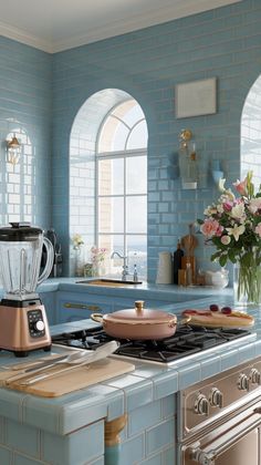 a kitchen with blue walls and an oven in the center, surrounded by windows that look out onto the ocean