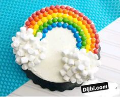 there is a cake with marshmallows on it and a rainbow in the middle