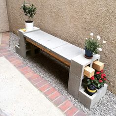 a concrete bench with potted plants on it