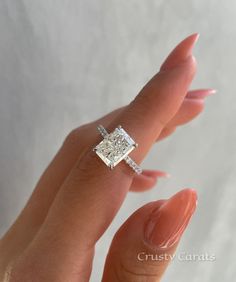 a woman's hand with a diamond ring on top of her finger and an engagement band