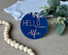 a blue badge with the words hello my name is alfafe next to some flowers