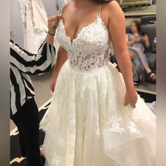 a woman in a wedding dress looking at herself in the mirror