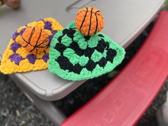 two crocheted basketballs sitting on top of a plastic chair next to each other