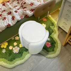 a small child's bedroom with a green bed and flower rug on the floor