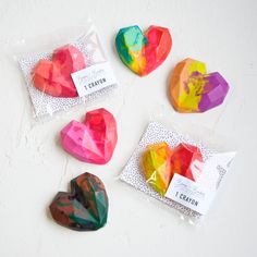 four heart shaped candies in cellophane bags on a white surface with labels