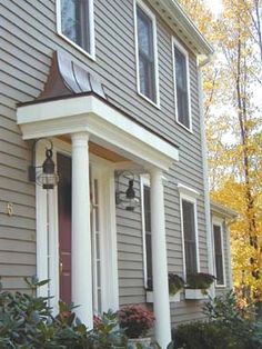 a gray house with white columns and windows