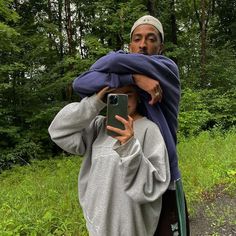 a man is taking a selfie with his cell phone in the middle of a forest