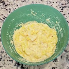 a green bowl filled with batter on top of a counter