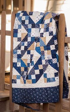 a blue and white quilt on a wooden chair