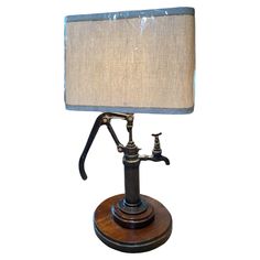 a lamp that is on top of a wooden base with a fabric shade over it