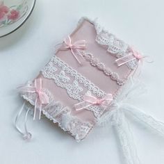 a small pink book with lace and bows on it