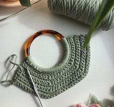 a green crochet purse with a pair of scissors next to it