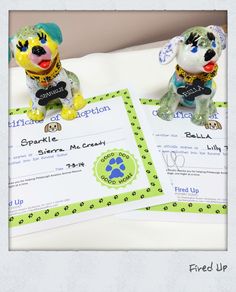 two dog figurines sitting on top of each other next to a cheque certificate