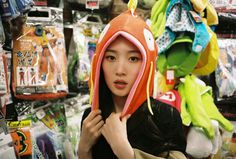 a woman is standing in front of a pile of stuffed animals and other stuff items