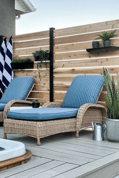 two wicker chaise lounge chairs sitting on a deck next to a hot tub