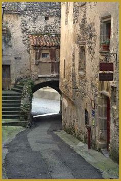 an alley way with stairs leading up to the top and below, in front of a stone building