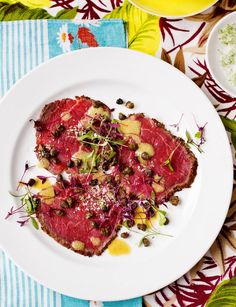 a heart shaped piece of meat on a plate with garnishes and seasonings