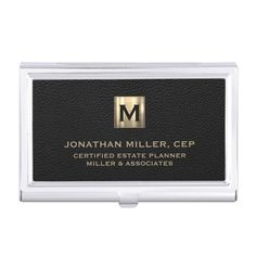 a black and gold business card holder with the letter m on it's front