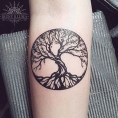 a black and white tree tattoo on the arm