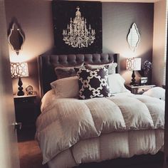 a bedroom with a chandelier hanging above the bed