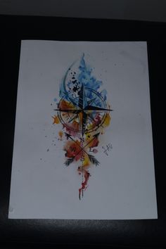 a clock with arrows painted on it in the middle of a black framed piece of paper