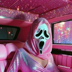 a person in a pink car with a ghost mask on