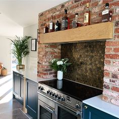 a kitchen with an oven, stove and counter top in front of a brick wall