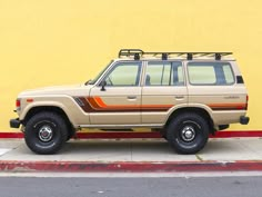 an suv parked in front of a yellow wall